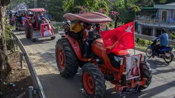 Para petani mengendarai traktor membawa poster pemimpin sipil Myanmar Aung San Suu Kyi yang ditahan saat demonstrasi menentang kudeta militer di Thongwa, di Yangon (12/2/2021).  Setelah melakukan kudeta militer Myanmar Tatmadaw telah menyatakan status darurat selama setahun. (AFP/STR)