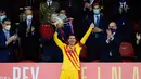 Penyerang Barcelona Lionel Messi mengangkat trofi Copa del Rey (Piala Raja) usai mengalahkan Atletico Bilbao pada final di stadion La Cartuja di Sevilla pada 17 April 2021. KIemungkinan Messi akan bergabung dengan klub kaya seperti Manchester City atau PSG. (Handout / RFEF / AFP)