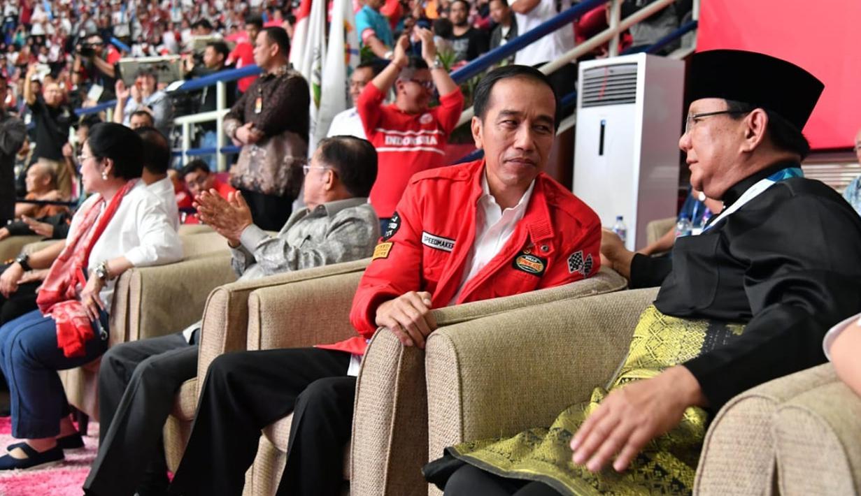 Presiden Joko Widodo atau Jokowi dan Ketua Umum Pengurus Besar Ikatan Pencak Silat Indonesia (IPSI) Prabowo Subianto berbincang saat menyaksikan pencak silat Asian Games 2018 di Jakarta, Rabu (29/8). (Liputan6.com/HO/Biro Pers Setpres)