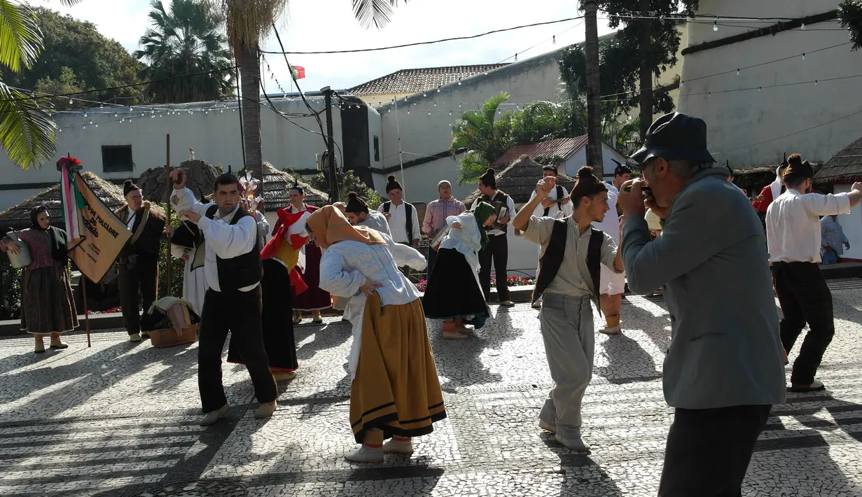 Sejumlah warga menari tarian tradisional khas Funchal, Portugal. Kota ini merupakan tempat bintang Real Madrid, Cristiano Ronaldo, lahir dan dibesarkan. (Bola.com/Reza Khomaini)