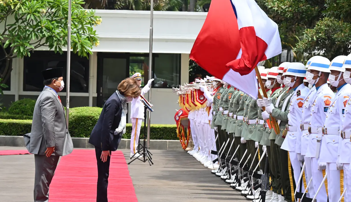 Menteri Angkatan Bersenjata Prancis Florence Parly (tengah) menunduk ke arah bendera nasional di sebelah Menteri Pertahanan Indonesia Prabowo Subiakto (kiri) selama kunjungan di Kementerian Pertahanan di Jakarta, Kamis (10/2/2022). (AFP/Adek Berry)