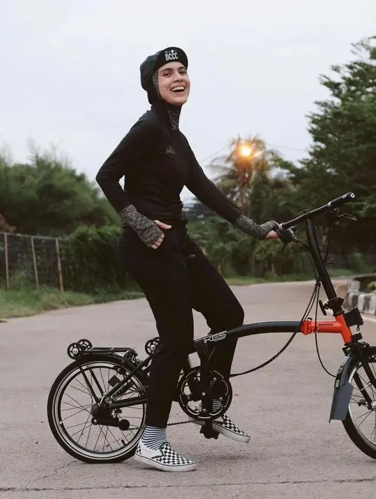 Saat bersepeda, Nycta Gina mengandalkan long tracksuit warna hitam yang senada dengan hijabnya. [Foto: IG/missnyctagina].