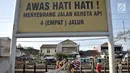 Warga menyeberangi perlintasan rel kereta api di kawasan Pisangan Baru, Jakarta, Selasa (10/9/2019). Mereka nekat menantang maut menyeberangi rel di dekat stasiun Jatinegara tersebut lantaran tidak adanya akses jembatan penyeberangan orang (JPO). (merdeka.com/Iqbal Nugroho)