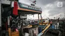 Nelayan beraktivitas di perahu saat bersandar di Pelabuhan Muara Angke, Jakarta, Senin (26/12/2022). Akibat angin  barat dan gelombang tinggi menyebabkan nelayan tradisional di Muara Angke libur melaut. (Liputan6.com/Faizal Fanani)