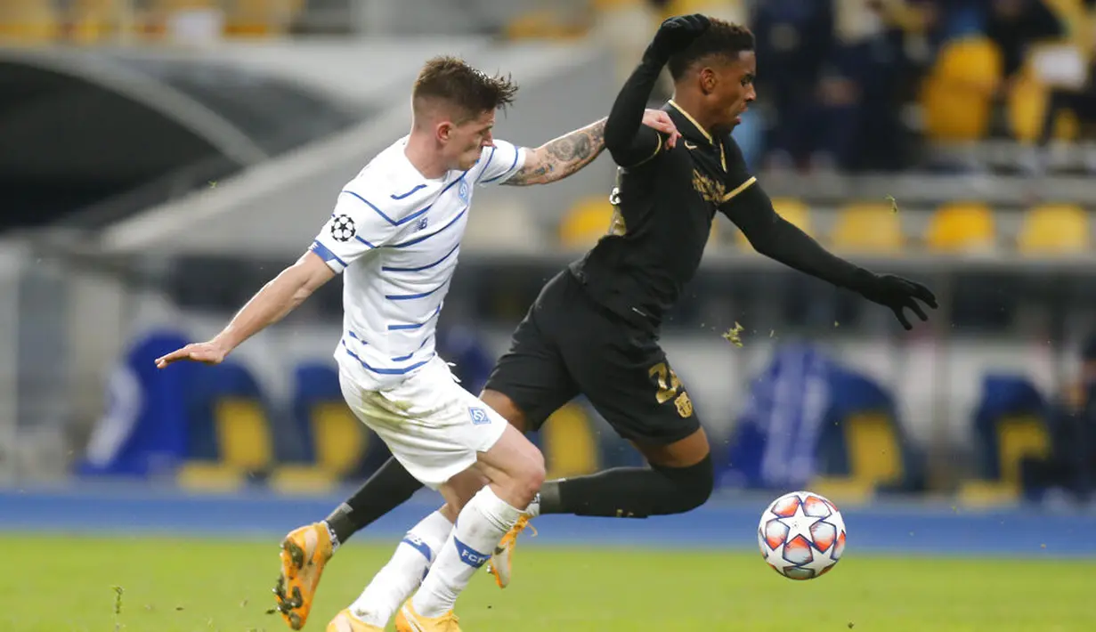 Pemain Barcelona Junior Firpo (kanan) berduel dengan pemain Dynamo Kyiv Oleksandr Andriyevskyi pada pertandingan Grup G Liga Champions di Stadion Olimpiyskiy, Kyiv, Ukraina, Selasa (24/11/2020). Barcelona membantai Dynamo Kyiv 4-0. (AP Photo/Efrem Lukatsky)