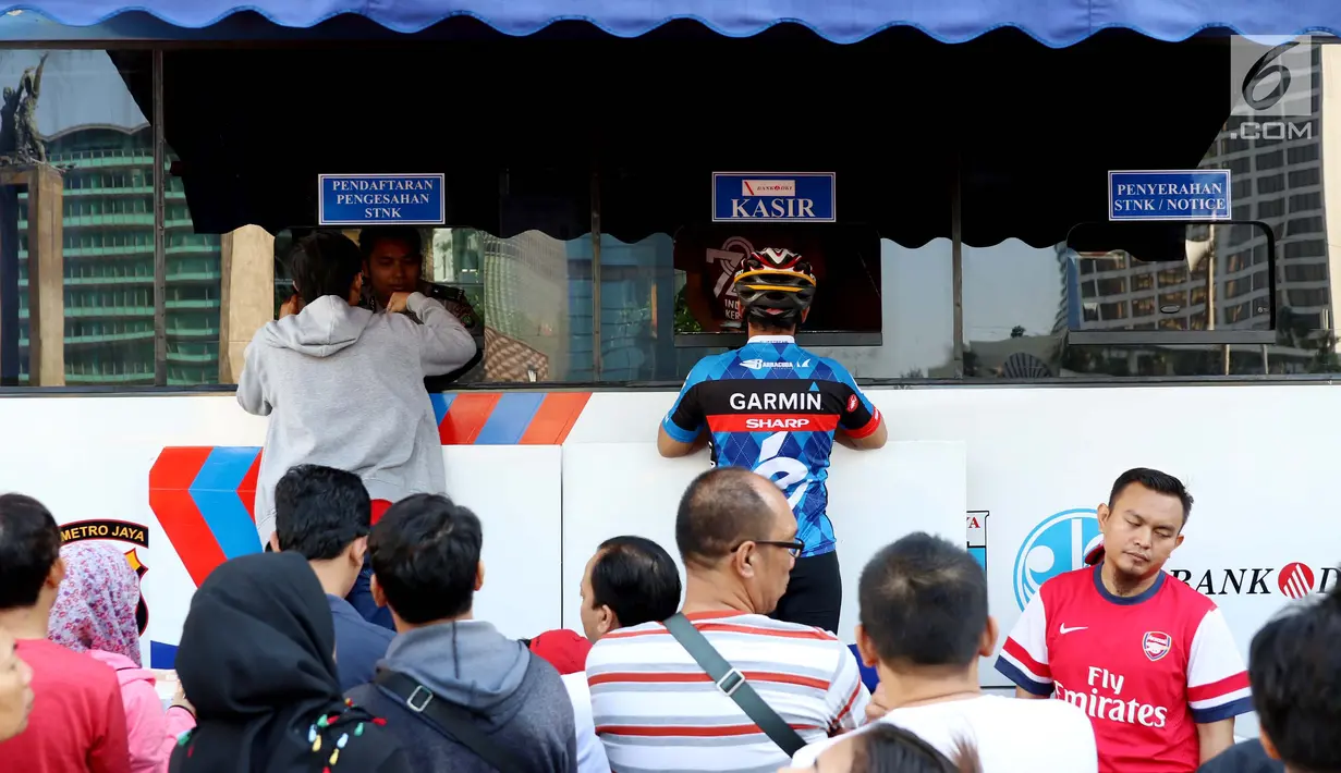 Warga membayar pajak kendaraan bermotor di samsat keliling di car free day, Jakarta, Minggu (27/8). Layanan pembayaran pajak Surat Tanda Nomor Kendaraan (STNK) bisa dilakukan tanpa membawa salinan atau BPKB. (Liputan6.com/Angga Yuniar)
