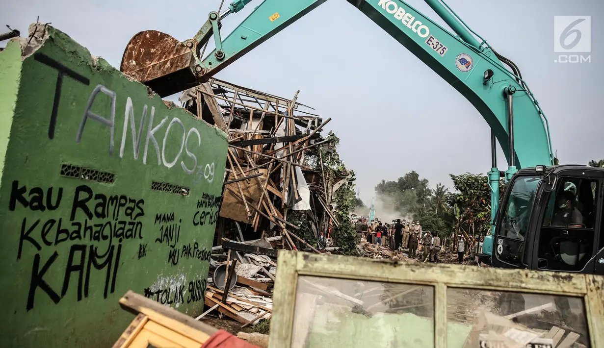 Sebuah alat berat digunakan untuk penertiban bangunan dikawasan bantaran Kali Ciliwung, Kelurahan Bukit Duri, Jakarta, Selasa (11/7). Sebanyak 345 bidang bangunan ditertibkan hari ini dengan target 333 kepala keluarga (KK). (Liputan6.com/Faizal Fanani)