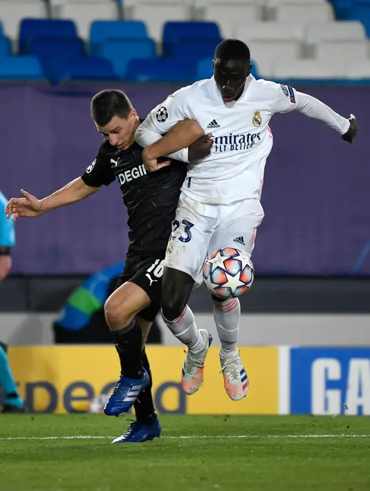 Bek Borussia Monchengladbach, Stefan Lainer berebut bola dengan bek Real Madrid, Ferland Mendy pada pertandingan Grup B Liga Champions di Estadio Alfredo Di Stefano, Kamis (10/12/2020). Madrid menang atas Monchengladbach 2-0. (AFP/PIERRE-PHILIPPE MARCOU)