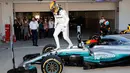 Lewis Hamilton keluar dari mobil untuk merayakan kemenangannya pada GP F1 Jepang di Sirkuit Suzuka, Jepang, (8/10). Hamilton mengoleksi 306 poin atau unggul 59 poin dari Vettel yang gagal finis di Suzuka. (AP Photo / Eugene Hoshiko)