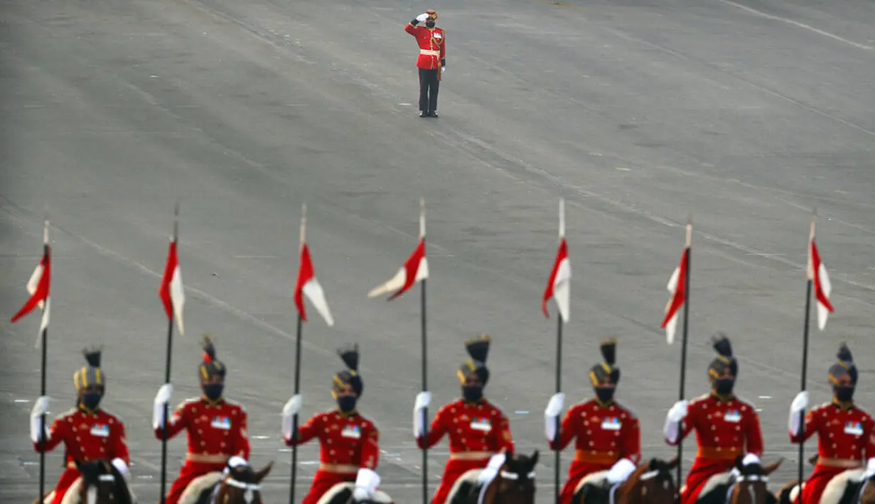 Seorang konduktor band militer India memberi hormat pada awal upacara Beating Retreat di Raisina Hills, pusat kekuasaan pemerintah, New Delhi, India, Jumat (29/1/2021). Upacara tersebut menandai akhir dari perayaan Hari Republik tahunan. (AP Photo/Manish Swarup)