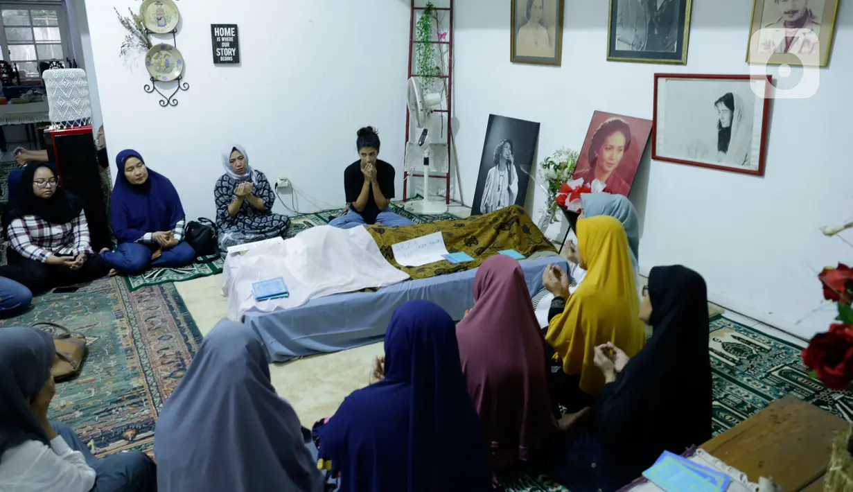 Sejumlah kerabat dan anggota keluarga berdoa di dekat jenazah artis senior Ade Irawan di rumah duka kawasan Lebak Buluk, Jakarta Selatan, Jumat (17/1/2020). Ibunda Ria Irawan tersebut meninggal dunia di Rumah Sakit Fatmawati pada Jumat (17/1/2020) pada usia 82 tahun. (Liputan6.com/Johan Tallo)