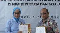 Direktur Utama (Dirut) PT BPR Intan Jabar atau bank BIJ Garut Dani Hadian dan Kajari Garut Neva Sari Susanti menunjukan dokumen MoU pendampingan hukum bagi Bank BIJ Garut, Jawa Barat. (Liputan6.com/Jayadi Supriadin)