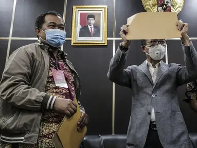 Koordinator MAKI Boyamin Saiman (kiri) menyerahkan salinan surat jalan Djoko Tjandra kepada Ketua Komisi III DPR Herman Herry di Kompleks Parlemen, Jakarta, Selasa (14/7/2020). Komisi III DPR diminta mengawasi polemik buron kasus korupsi hak tagih Bank Bali tersebut. (Liputan6.com/Johan Tallo)