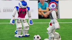 Robot tim 'Nomadz' dari Swiss (kaos merah) berusaha menghadang robot tim 'Hulk' dari Jerman saat saat pertandingan Liga Platform Standar di RoboCup GermanOpen 2018, Magdeburg, Jerman (28/4). Acara ini diikuti oleh 16 negara. (AP/Jens Meyer)