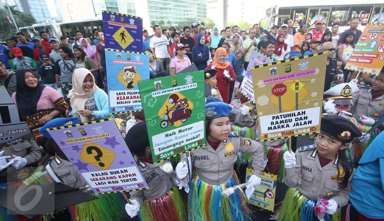 Puluhan polisi cilik membawa poster himbauan patuhi lalu lintas saat melakukan kampanye keselamatan berkendara di kawasan Bundaran HI, Jakarta, Minggu (12/3). (Liputan6.com/Immanuel Antonius)