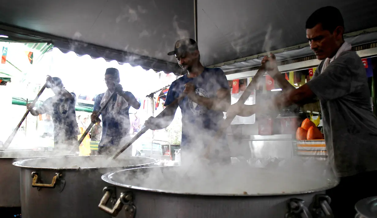 Sejumlah orang sedang memasak Bubur Lambuk di desa Kampung Baru, Kuala Lumpur, Malaysia, Kamis (1/6). Bubur Lambuk menjadi makanan khas Ramadan di Malaysia. (AP/Daniel Chan)