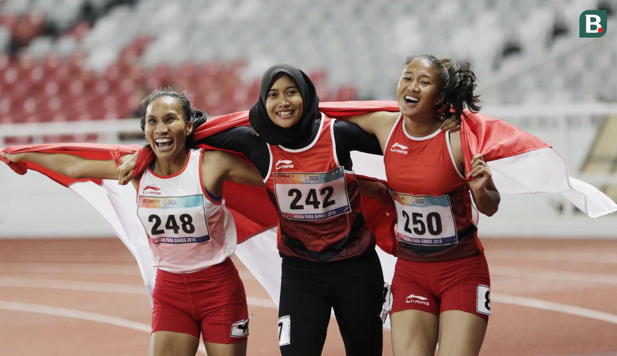 Pelari Indonesia, Putri Aulia, Ni Made Arianti, Endang Sari Sitorus, melakukan selebrasi usai menjuarai lari 100M T13 pada Asian Para Games di SUGBK, Jakarta, Rabu (10/10/2018). Indonesia meraih memborong tiga mendali. (Bola.com/M Iqbal Ichsan)