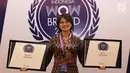 Head of Protocol Public Affair PT Surya Citra Media Tbk (SCMA) Irnawati WK menunjukkan 2 penghargaan Gold Champion yang diraih SCTV dan Indosiar  dalam kategori Free-to-Air TV. (Liputan6.com/Immanuel Antonius)