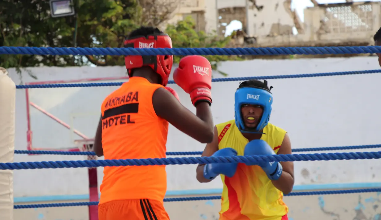 Petinju Somalia, Kashmir Abdirahim Abdalla (kiri) bertanding Mogadishu pada 15 November 2018. Pertandingan tinju pertama di Somalia setelah konflik itu digelar di lapangan basket yang disulap menjadi area pertarungan. (Abdirazak Hussein FARAH / AFP)