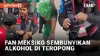 Aturan ketat di Piala Dunia 2022 Qatar membuat penggemar harus menahan diri. Salah satunya adalah pelarangan alkohol di area stadion. Namun fan Meksiko ini berusaha mengelabui petugas keamanan dengan memasukkan alkohol dalam teropong.