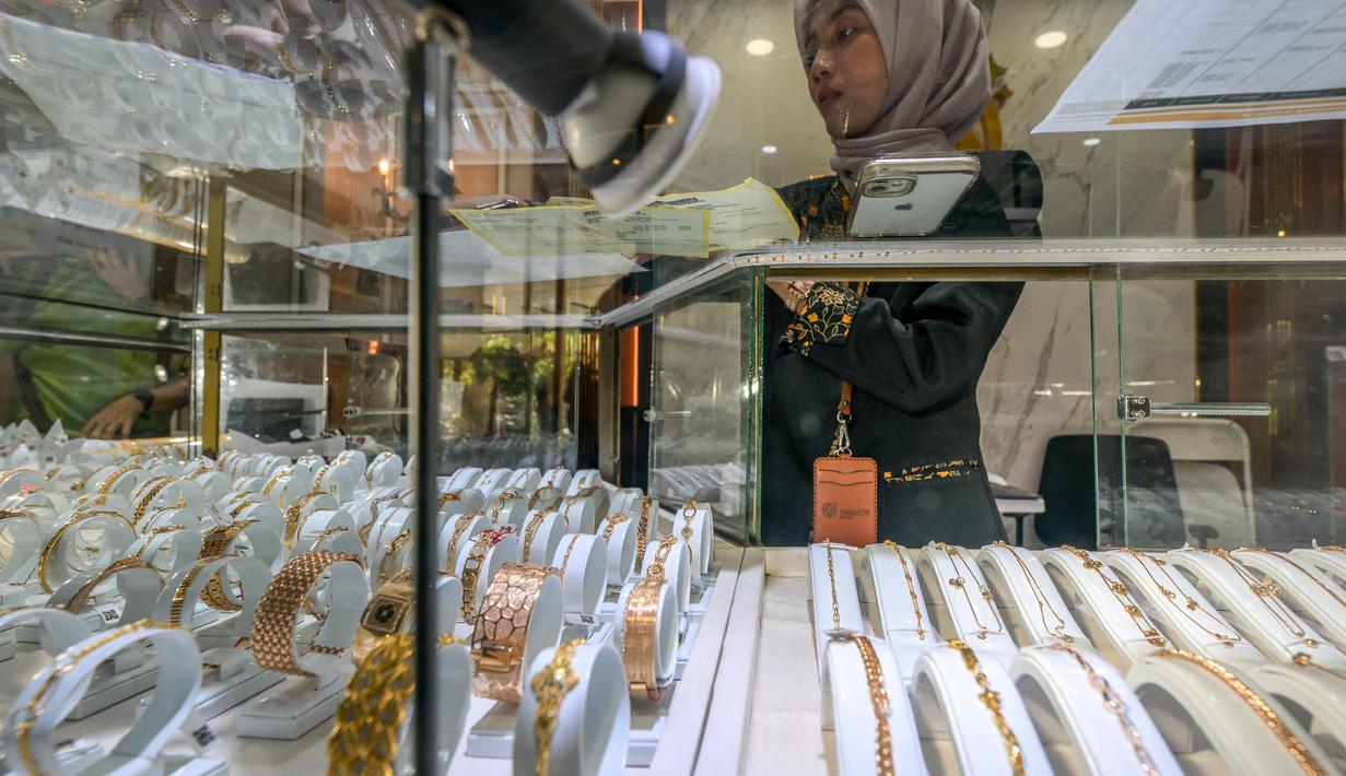Penurunan ini terjadi setelah sebelumnya pada Minggu (13/4/2025) mencetak rekor hampir Rp2 juta per gram. (BAY ISMOYO/AFP)
