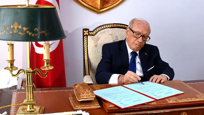 Dalam foto yang disediakan oleh kepresidenan Tunisia, Presiden Beji Caid Essebsi menandatangani sebuah dekrit di ibu kota Tunis pada 5 Juli 2019. Presiden tertua di dunia ini meninggal dunia di usia 92 tahun pada Kamis (25/7/2019). (Slim Abid/Tunisian Presidency via AP)
