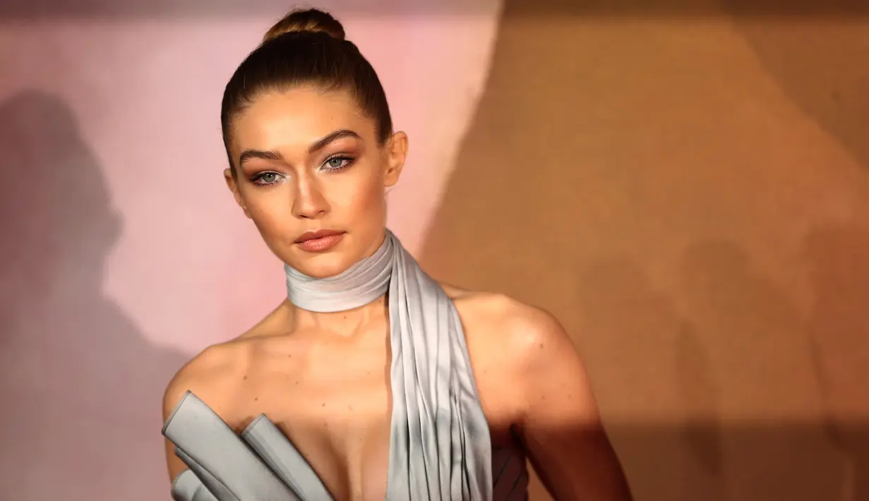 Penampilan supermodel Gigi Hadid saat berpose di karpet merah acara Fashion Awards 2016 di London, Senin (5/12). Pacar Zayn Malik ini tampil mengesankan dengan jumpsuit simetris warna silver yang futuristik. (REUTERS/Neil Hall)