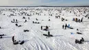 Pemancing di dekat lubang pemancingan saat Brainerd Jaycees Ice Fishing Extravaganza tahunan ke-32 di Gull Lake's Hole di Teluk Day, Minnesota pada 29 Januari 2022. Hampir 10.000 pemancing dari Minnesota dan negara bagian lain menghadiri kontes memancing es amal terbesar di dunia. (Kerem Yucel/AFP)