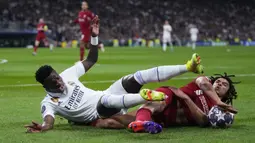 Pemain Liverpol, Trent Alexander-Arnold (kiri) berebut bola dengan pemain Real Madrid, Vinicus Junior pada laga 16 besar Liga Champions 2022/2023 yang berlangsung di Santiago Bernabeu, Madrid, Spanyol, Kamis (16/03/2023) WIB. Laga dimenangkan oleh Real Madrid dengan skor 1-0. (AP Photo/Manu Fernandez)