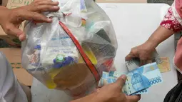 Warga membeli sembako murah di Kantor Kelurahan Cililitan, Jakarta, Rabu (2/2/2022). Pasar murah ini menyediakan minyak goreng dengan harga subsidi yakni Rp 14.000 per liter, beras 5kg dengan harga Rp 55.000 serta telur, susu UHT, gula pasir dan tepung terigu. (Liputan6.com/Herman Zakharia)
