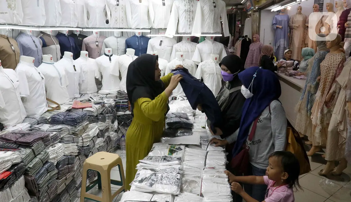 Pedagang membantu calon pembeli memilih busana di Pasar Tanah Abang Blok A, Jakarta, Rabu (6/3/2024). (Liputan6.com/Herman Zakharia)