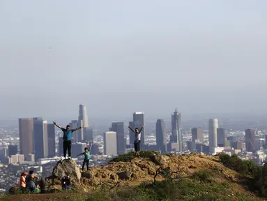 Wisatawan berpose di kawasan Griffith Observatory & Planetarium, California (14/3/2016). Di belakang mereka tampak Kota Los Angeles (Reuters/ Mario Anzuoni)