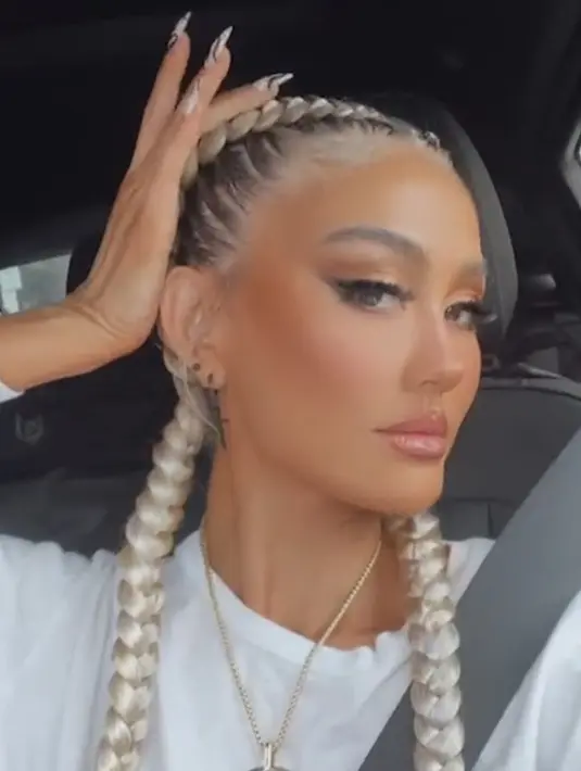 Agnez Mo baru saja menggunggah sebuh video dari Instagram Livenya. Ia tampil dengan makeup glamour dengan riasan mata coral dan eyeliner eings, full lips sehingga nampak bibirnya tebal, dan contouring tebal yang menonjolkan pipinga. Dengan gaya rambut dutch braid di rambut abu-abuanya. @agnezmo