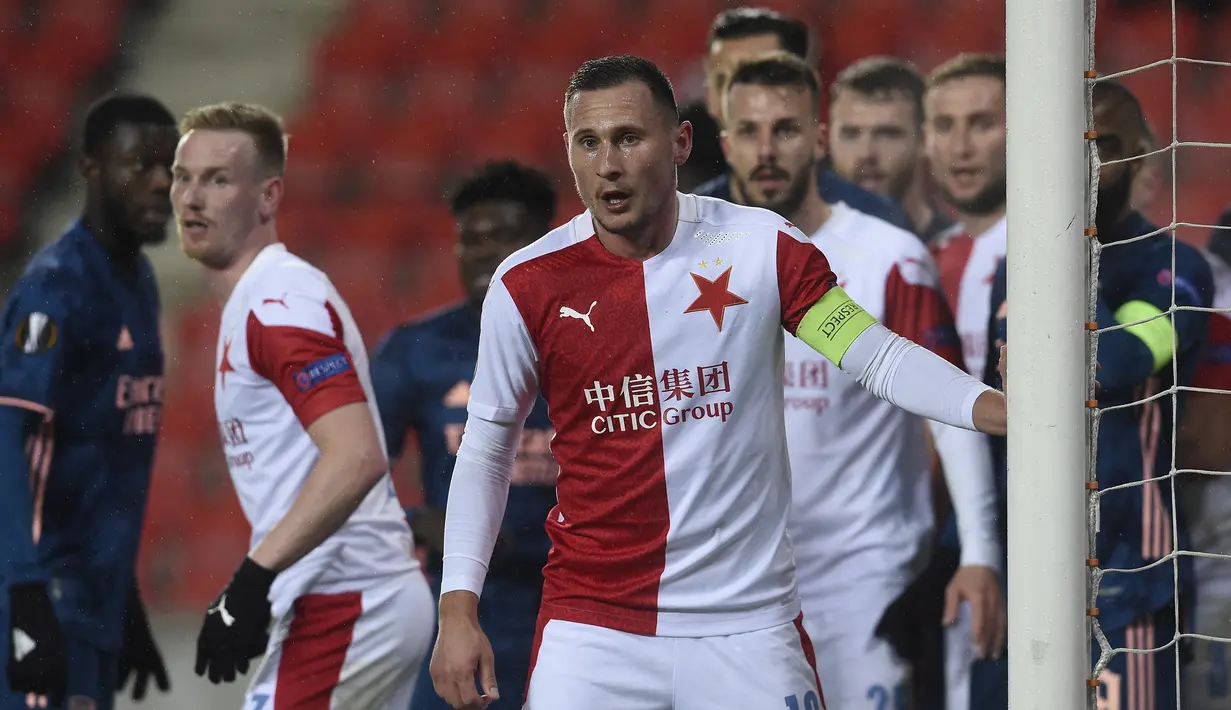 Bek Slavia Praha, Jan Boril (depan) bersiap mengantisipasi umpan sepak pojok pemain Arsenal dalam laga leg kedua perempatfinal Liga Europa 2020/2021 di Sinobo Stadium, Praha, Kamis (15/4/2021). Slavia Praha kalah 0-4 dari Arsenal. (AFP/Michal Cizek)