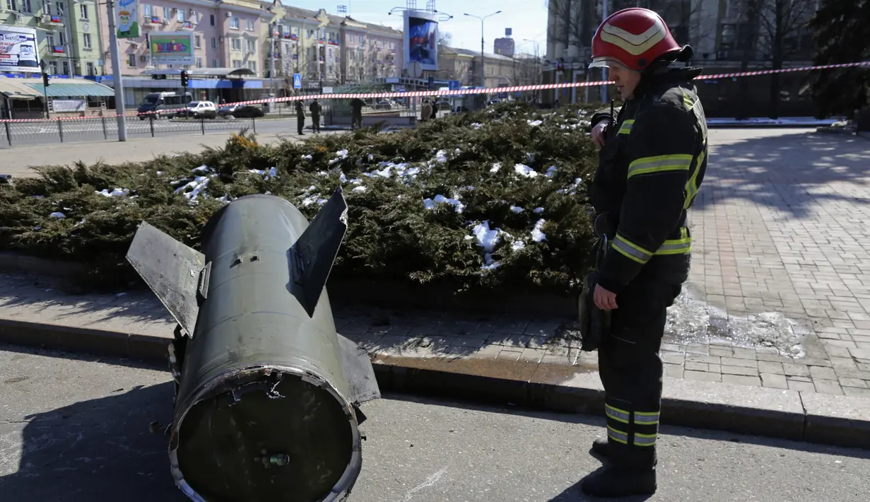 Seorang petugas pemadam kebakaran melihat pecahan rudal Tochka-U Ukraina di sebuah jalan di Donetsk di Ukraina timur, Senin, 14 Maret 2022. Militer Rusia mengatakan bahwa sedikitnya 20 warga sipil tewas oleh rudal balistik yang diluncurkan oleh pasukan Ukraina. (AP Photo/Alexei Alexandrov)