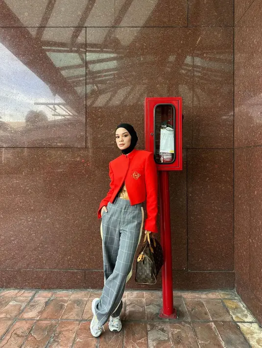 Tantri memadukan warna merah pada structured crop outernya dengan celana panjang abu-abu bercorak garis kotak-kotak. [Foto: Instagram/tantrinamirah]