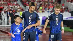 Pemain Jepang, Hidemasa Morita (kedua kiri) menuntun anak kecil yang ditugaskan sebagai player escort dalam pertandingan lanjutan putaran ketiga Grup C Kualifikasi Piala Dunia 2026 melawan Timnas Indonesia di Stadion Utama Gelora Bung Karno (SUGBK), Senayan, Jakarta, Jumat (15/11/2024). (Bola.com/Bagaskara Lazuardi)