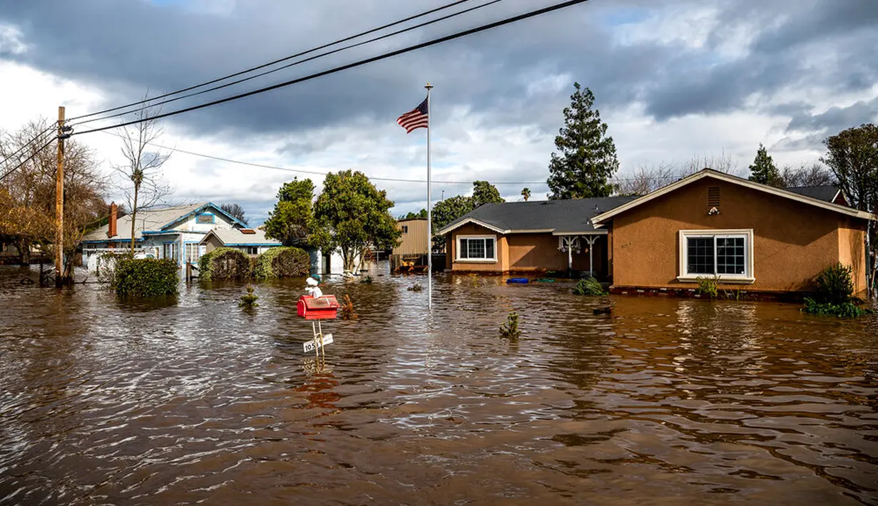 Banjir akibat badai mengelilingi rumah di Thornton Rd, Merced, California, Amerika Serikat, 10 Januari 2023. Serangkaian badai yang menghantam California telah menyebabkan jalanan terendam banjir, gelombang tinggi air laut, sungai meluap, dan memaksa ribuan orang untuk mengungsi. (AP Photo/Noah Berger)