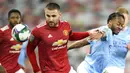 Striker Manchester City, Raheem Sterling, berebut bola dengan pemain bek Manchester United, Luke Shaw, pada laga Piala Liga Inggris di Stadion Old Trafford, Rabu (6/1/2021). City menang dengan skor 2-0. (Peter Powell/Pool via AP)