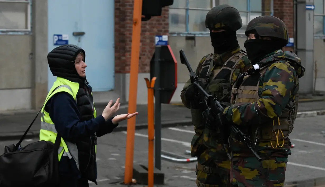Tentara Belgia (kanan) melakukan penjagaan di dekat bandara Zaventem, Brussels, Belgia, (23/3). Belgia mengadakan tiga hari berkabung untuk menghormati 35 orang tewas dalam serangan teror. (JOHN THYS / AFP)