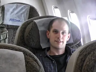 Dalam gambar yang diambil dari video yang disediakan oleh Dinas Keamanan Federal Rusia melalui RTR pada Kamis, 1 Agustus 2024, reporter Wall Street Journal Evan Gershkovich duduk di dalam pesawat di bandara di luar Moskow, Rusia. (Russian Federal Security Service/RTR via AP)