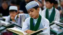 Ekspresi seorang anak saat mengikuti baca Alquran berjemaah selama bulan Ramadan di Masjid Imam Ali Ibn Abi Tholib di Najaf, Irak (2/6). Anak-anak di Irak ini mengisi bulan Ramadan dengan membaca Alquran berjemaah. (AFP/Haidar Hamdani)