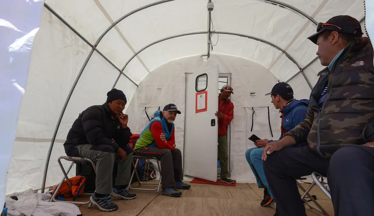 Pendaki menunggu antrean untuk menemui dokter di klinik tenda Everest ER di Everest Base Camp, sekitar 140 Km timur laut Kathmandu, Nepal, 24 April 2018. Saat ini, Everest ER dijalankan oleh Asosiasi Penyelamatan Himalaya. (PRAKASH MATHEMA/AFP)