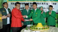 Perwakilan Partai koalisi, Hasto Kristiyanto (kiri)saat menerima potongan tumpeng dari Ketum PPP Romi (kanan), dalam acara peringatan Harlah ke-42 PPP, Jakarta, Senin (5/1/2015). (Liputan6.com/Andrian M Tunay)