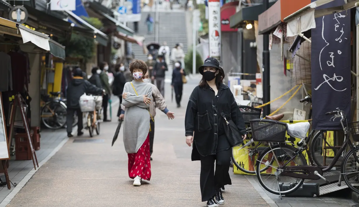 Orang-orang dengan masker wajah berjalan melalui jalan perbelanjaan di Tokyo (15/10/2020). Ibukota Jepang mengonfirmasi lebih dari 280 kasus virus korona baru pada hari Kamis. (AP Photo/Hiro Komae)