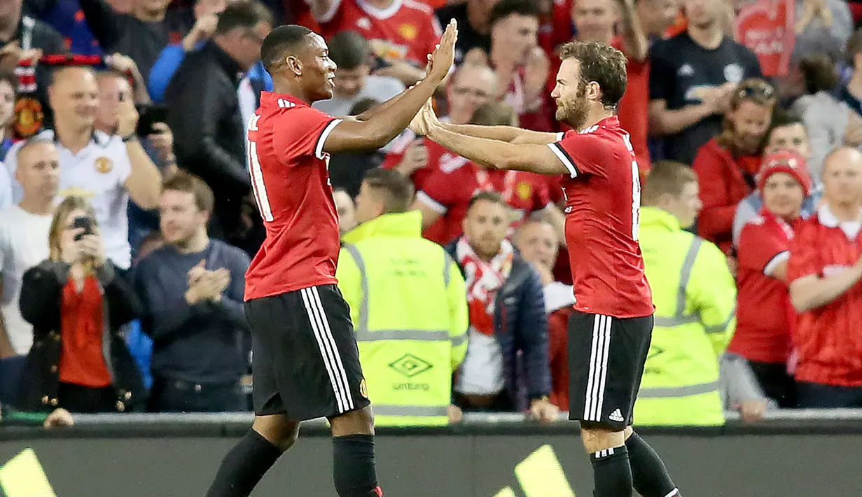 Gelandang Manchester United, Juan Mata (kiri) melakukan selebrasi dengan Anthony Martial usai mencetak gol ke gawang Sampdoria pada pertandingan pra musim di stadion Aviva di Dublin (2/8). MU menang atas Sampdoria dengan skor 2-1. (AFP Photo/Paul Imith)