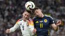 Pemain Jerman, Pascal Gross (kiri) berduel udara dengan pemain Skotlandia, Ryan Christie pada laga pembuka Grup A Euro 2024 di Allianz Arena, Munchen, Jerman, Sabtu (15/06/2024) WIB. (AP Photo/Antonio Calanni)