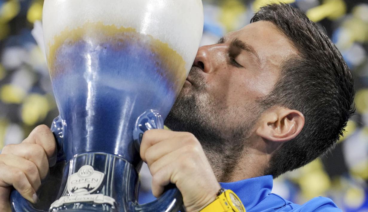 Petenis asal Serbia Novak Djokovic mencium trofi saat selebrasi menjuarai ATP Cincinnati Open 2023 dengan mengalahkan petenis asal Spanyol Carlos Alcaraz pada laga final di Mason, Ohio (20/8/2023). Djokovic menang dalam laga sengit 5-7, 7-6(9/7), 7-6(7/4). (AP Photo/Aaron Doster)