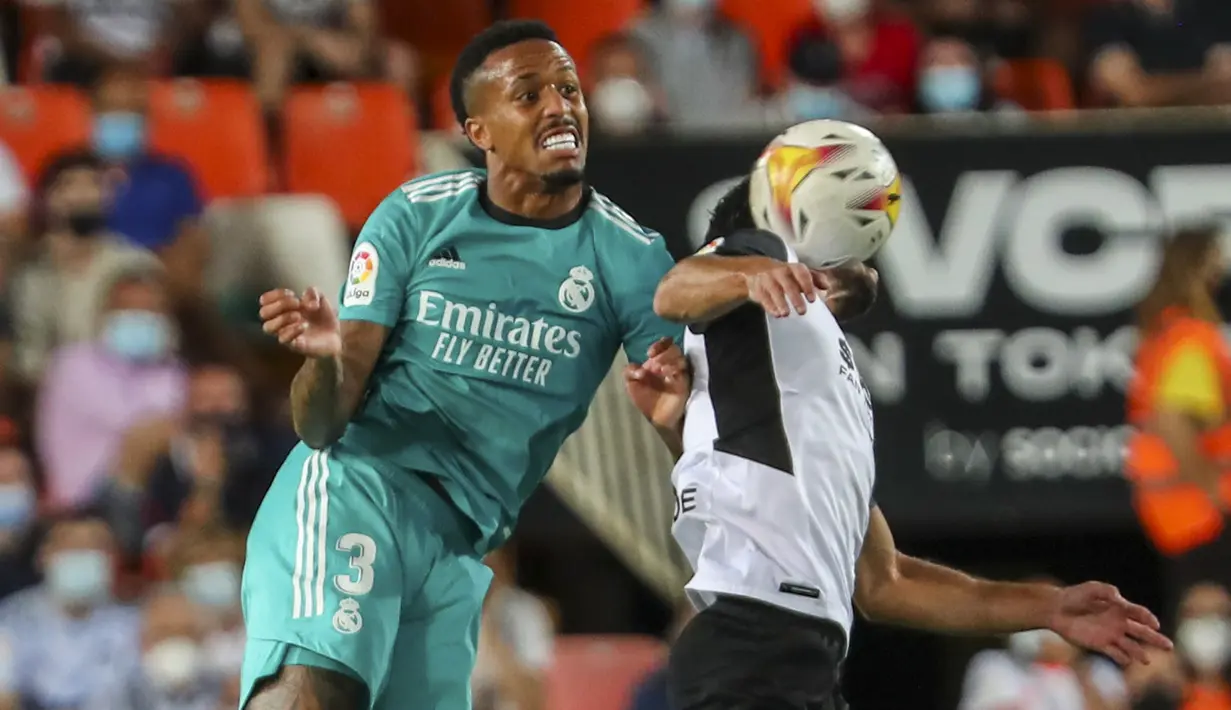 Bek Real Madrid, Eder Militao berebut bola dengan gelandang Valencia, Goncalo Guedes pada lanjutan La Liga di Stadion Mestalla, Senin (20/9/2021) dini hari WIB. Real Madrid menang 2-1 secara dramatis atas Valencia. (AP Photo/Alberto Saiz)