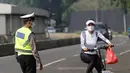 Petugas gabungan melakukan pengalihan jalur pesepeda di kawasan Sudirman-Thamrin, Jakarta, Minggu (5/9/2021). Pemberlakuan jalur ganjil genap pada masa PPKM membuat pengguna sepeda dilarang melintasi kawasan ganjil-genap pagi ini. (Liputan6.com/Angga Yuniar)